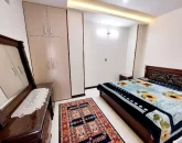 تخت خواب با روتختی رنگی و میز آرایش و کمد دیواری اتاق خواب آپارتمان در زرین شهر