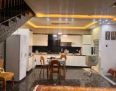 آشپزخانه با یخچال، کابینت های سفید و میز ناهارخوری، لباسشویی و کفپوش سرامیکی ویلا در اصفهان 586445
