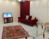 اتاق پذیرایی فرش شده به همراه مبلمان و تلوزیون آپارتمان در خمینی شهر 5641541