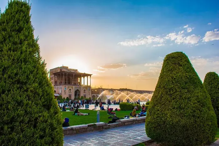 درختان سرسبز در کنار محوط سازی و ساختمان قدیمی عالی قاپو اصفهان و بازدید مردم از این محوطه 1564154