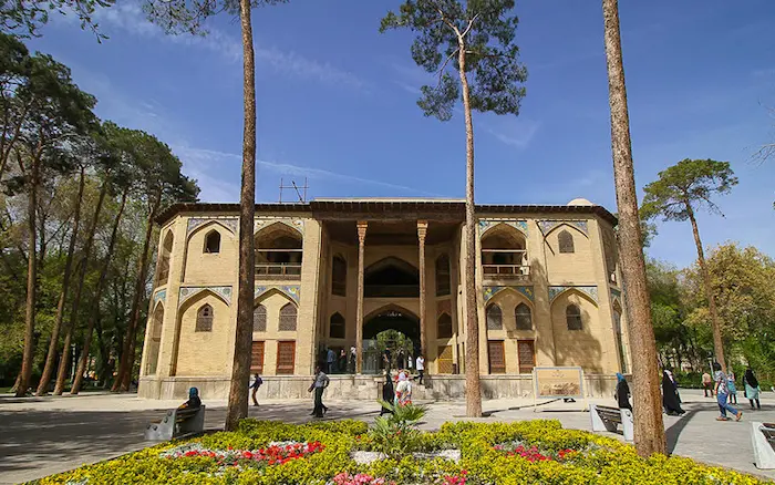 نمای ساختمان قدیمی کاخ هشت بهشت اصفهان در کنار درختان بلند قامت و بازدید مردم از این مکان 1541563