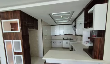 کابینت سفید و هود وسقف نور پردازی شده با نور سفید آشپزخانه آپارتمان در نجف آباد
